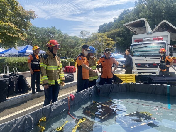 지난 27일 김승룡 소방청장 직무대행이(왼쪽 세번째) 국가정보자원관리원 화재 현장에서 소화수조에 담긴 불에 탄 리튬이온 배터리를 살펴보고 있다.